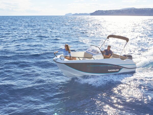 Quicksilver 475 aXess, boot varend op zee met kustlijn