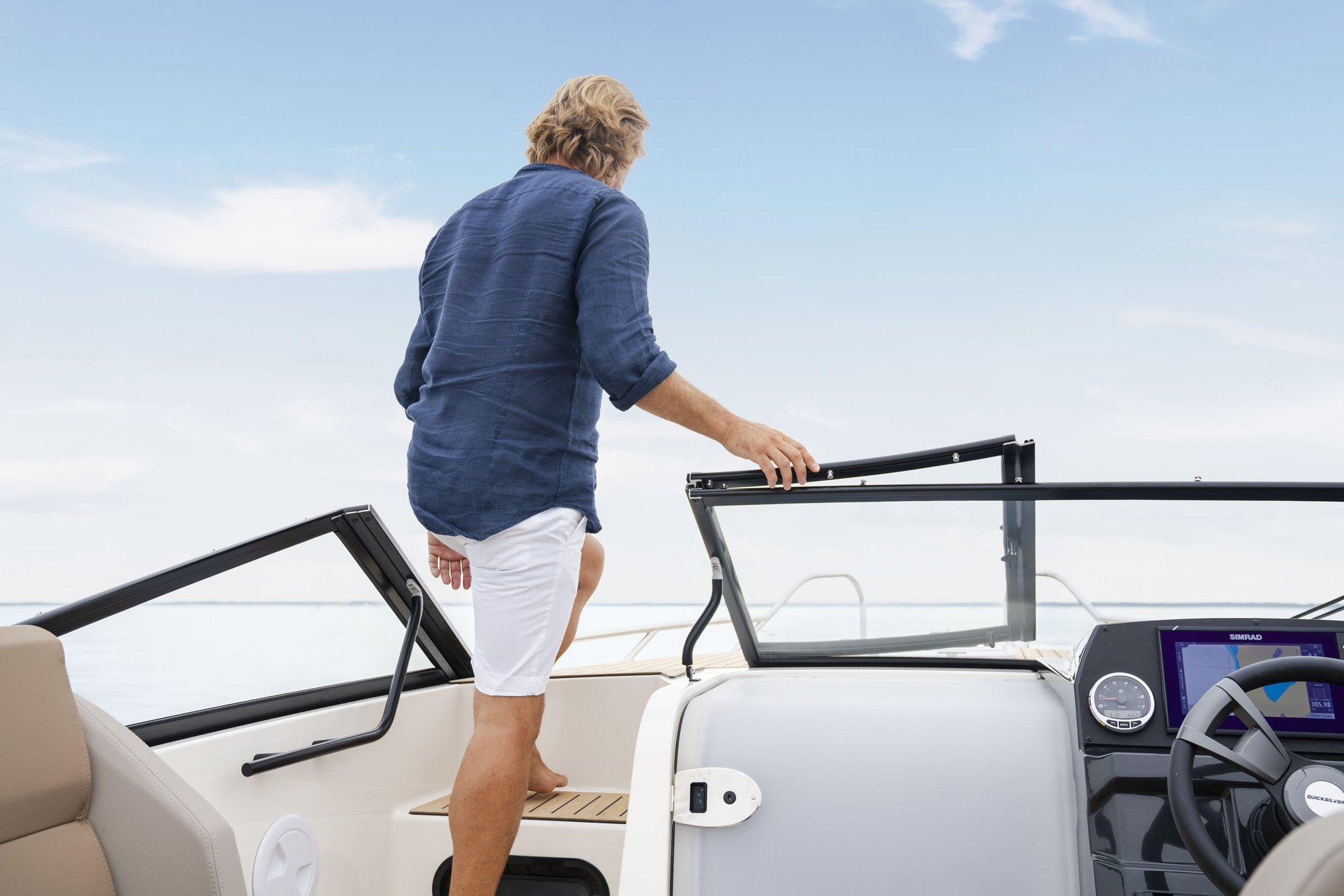 Quicksilver 605 Cruiser, man loopt naar voordek stuurstand