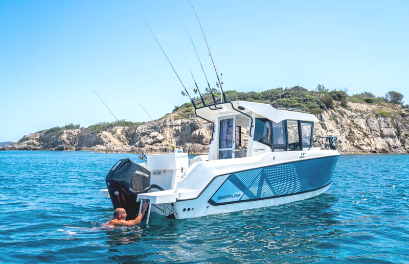 Quicksilver 705 Pilothouse, boot bij rotsachtige kust met zwemmer