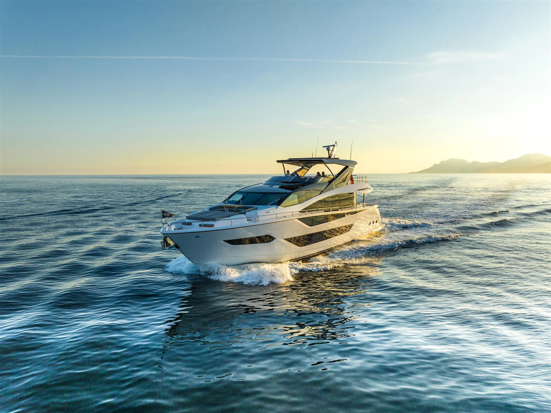 Sunseeker 88 Yacht, jacht varend op zee bij zonsondergang