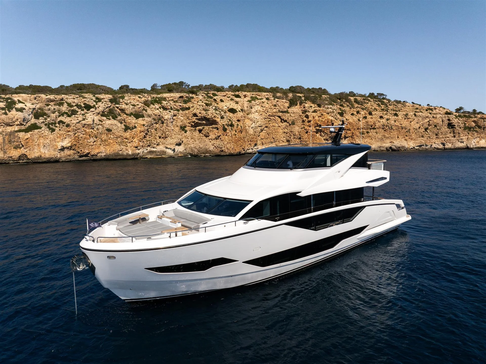 Sunseeker 90 Ocean Enclosed, witte jacht voor rotskust