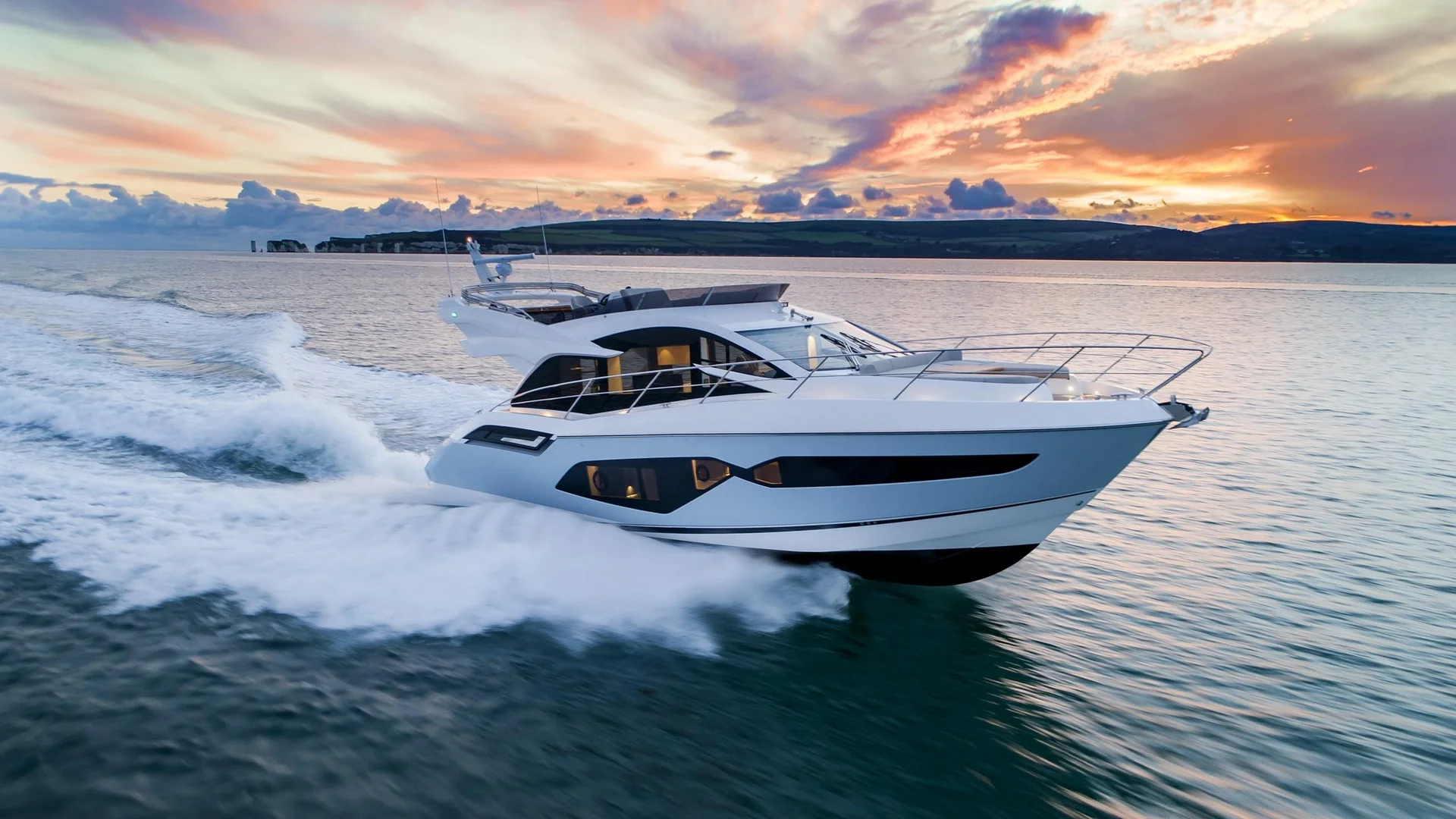 Sunseeker Manhattan 55, witte boot varend bij zonsondergang
