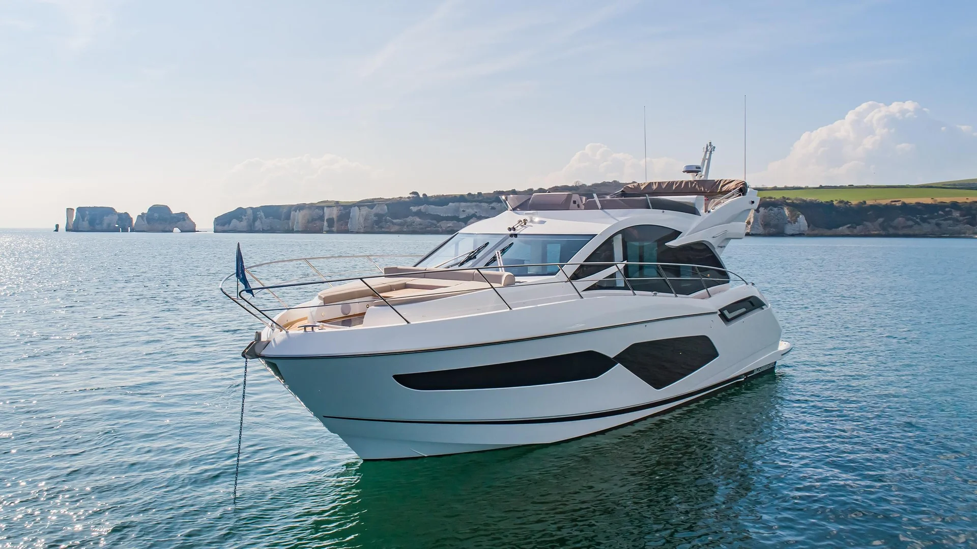 Sunseeker Manhattan 55, witte motorboot afgemeerd bij kust