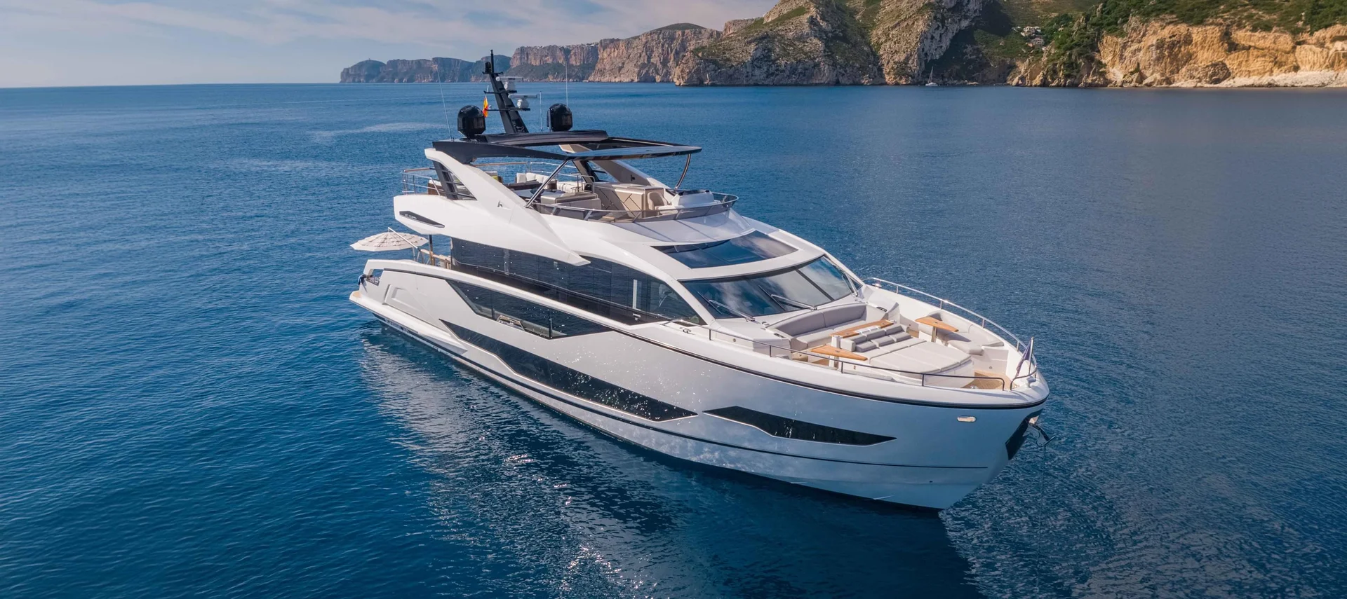 Sunseeker Manhattan 68, witte jacht op zee bij kust
