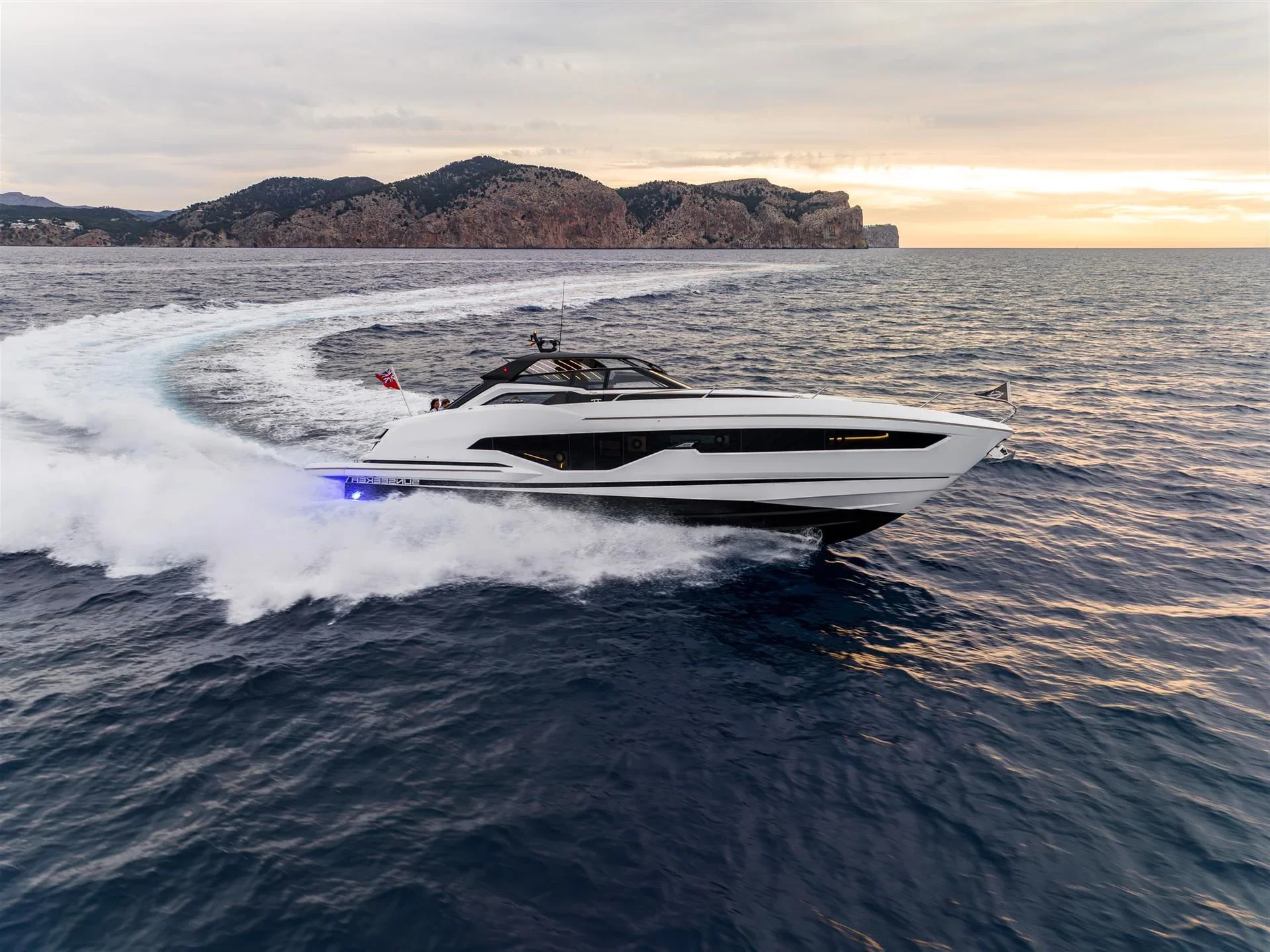 Sunseeker Superhawk 55, boot varend op zee bij zonsondergang