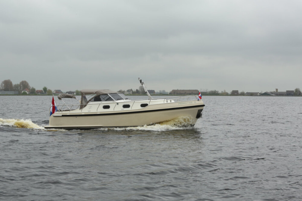 Vedette Cabin Classic Line 31 ft, witte motorboot varend op water