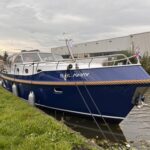Vedette Cabin Classic Line 36 ft, blauwe motorboot afgemeerd aan kade