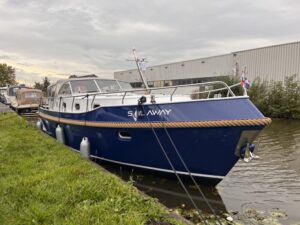 Vedette Cabin Classic Line 36 ft, blauwe motorboot afgemeerd aan kade