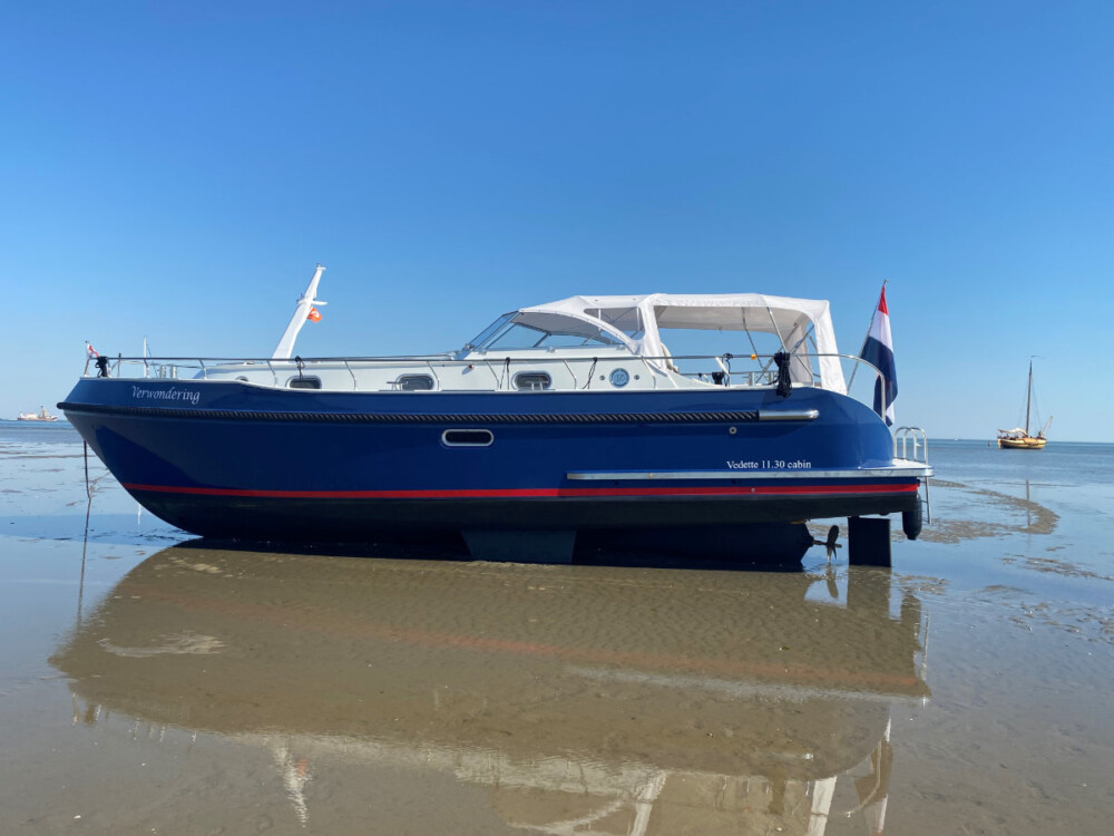 Vedette Cabin Classic Line 38 ft, blauwe boot op droogvallend wad