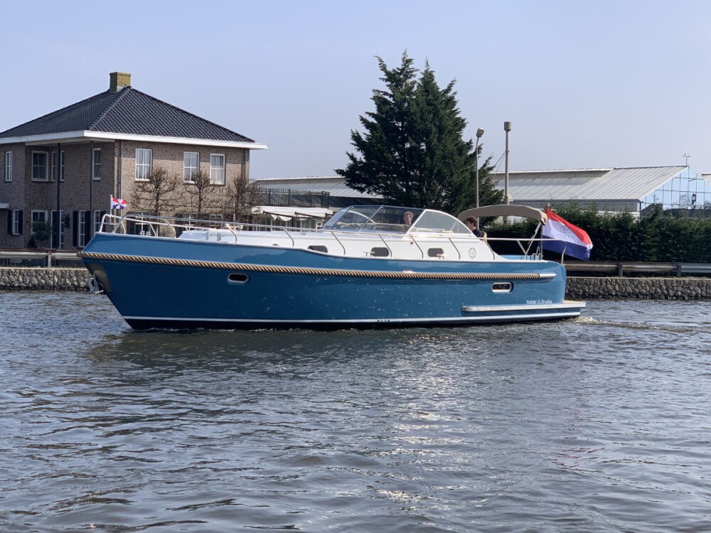 Vedette Cabin Classic Line 38 ft, blauwe motorboot varend op water