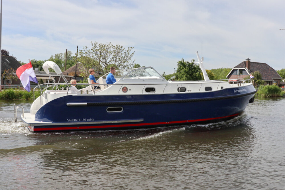 Vedette Cabin Classic Line 38 ft, blauwe motorboot varend op water