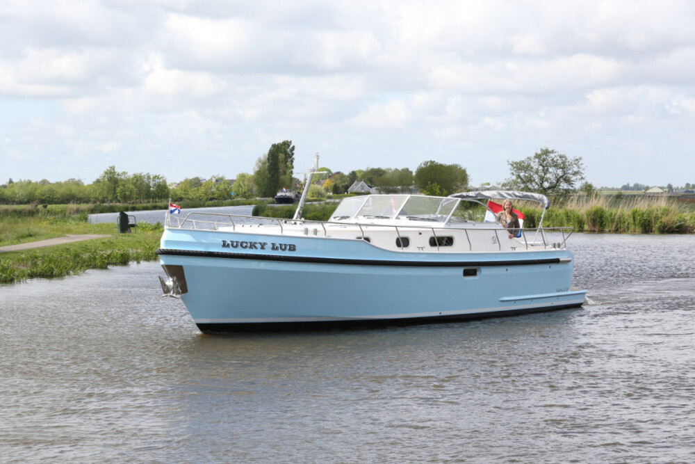 Vedette Cabin Classic Line 41 ft, lichtblauwe motorboot vaart op rivier