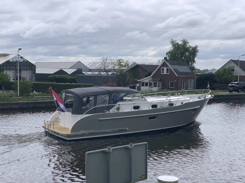 Vedette Cabin Comfort Line 37 ft, grijze motorboot vaart door kanaal