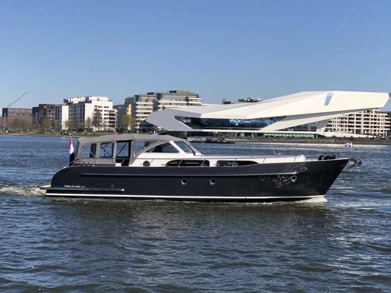 Vedette 46 Cabin Lounge, boot varend op water bij gebouwen