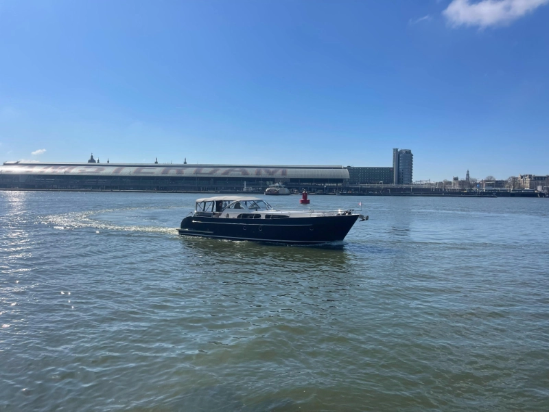 Vedette 46 Cabin Lounge, motorboot varend op water bij stad