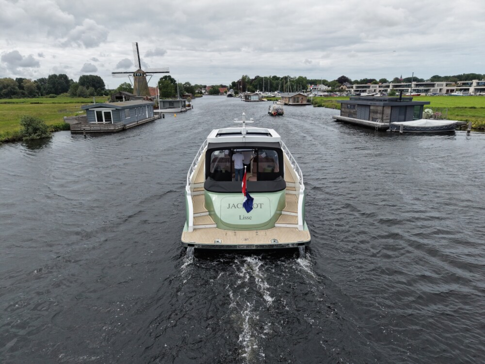 Vedette Premium Line 48, boot varend op rivier tussen woonboten