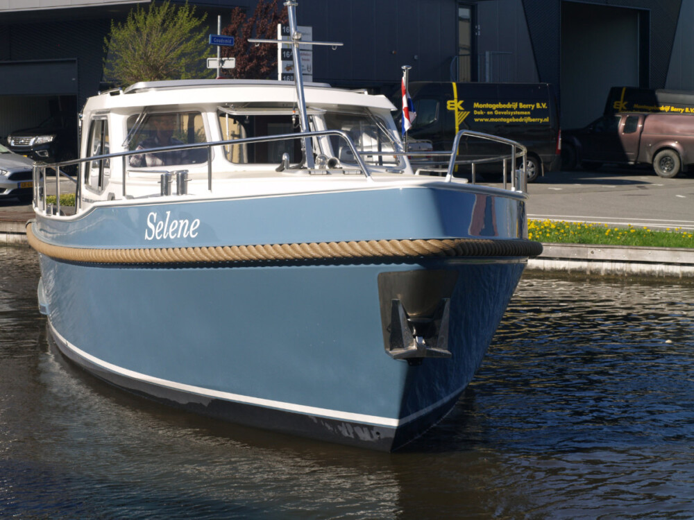 Vedette Salon Classic Line 36 ft, blauwe motorboot afgemeerd aan kade