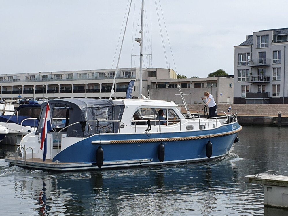 Vedette Salon Classic Line 36 ft, blauwe motorboot vaart door haven