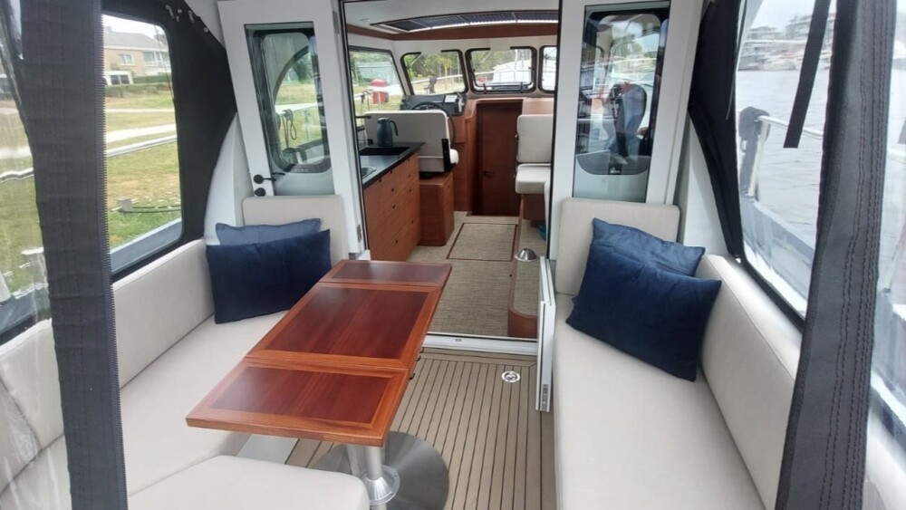 Vedette Salon Comfort Line 33 ft, kajuit met houten tafel en zitbanken