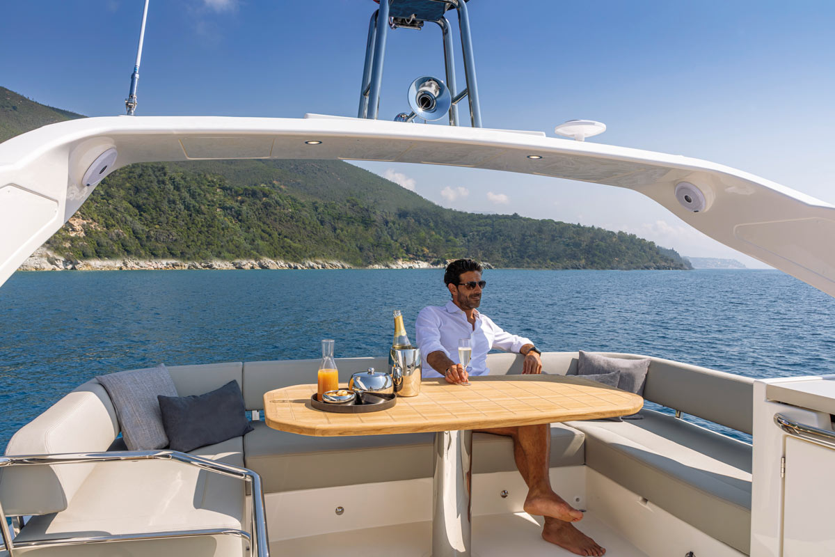 Absolute 47 FLY, man aan tafel op achterdek