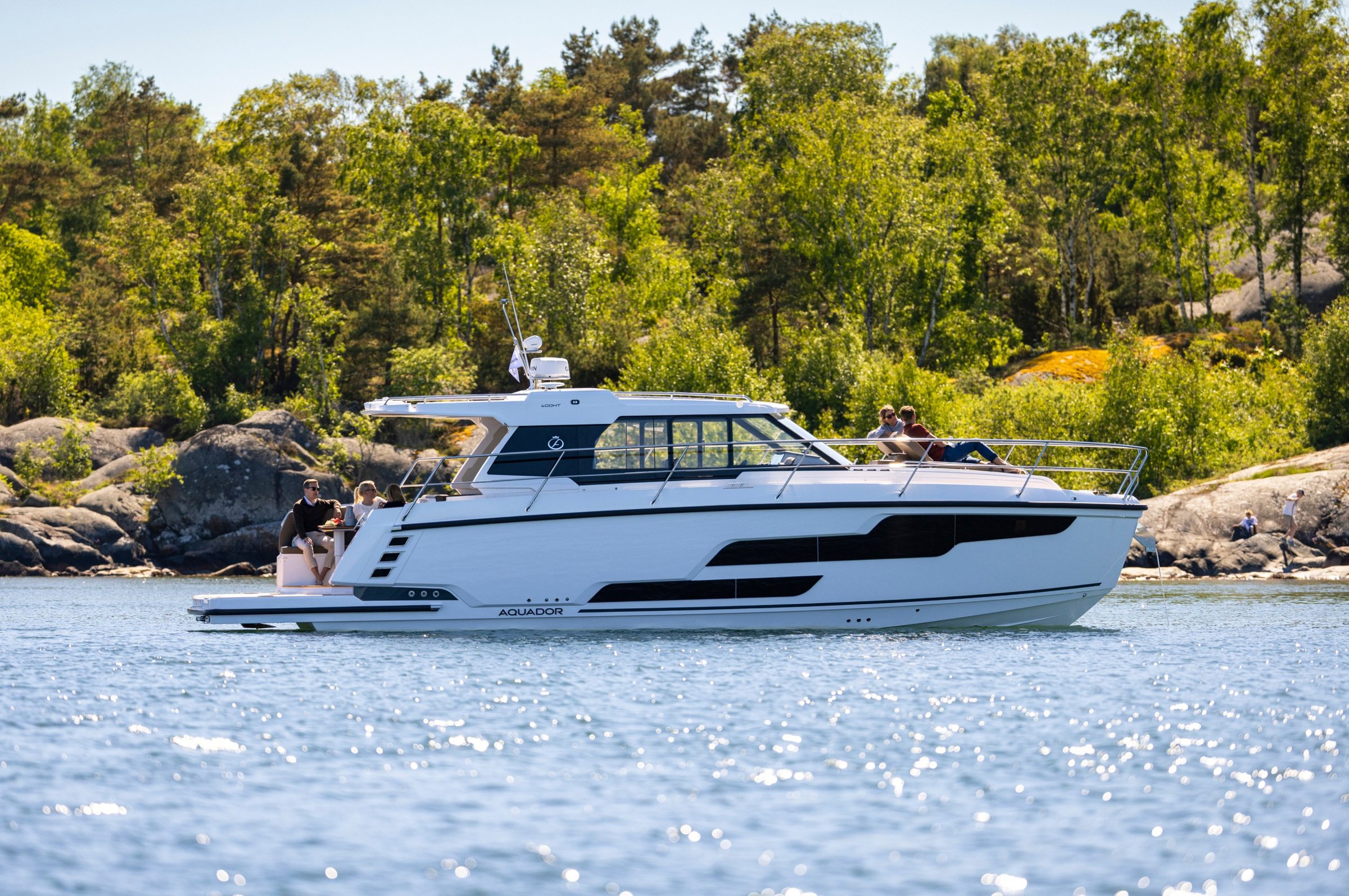 Aquador 400 HT, boot varend op water bij bos