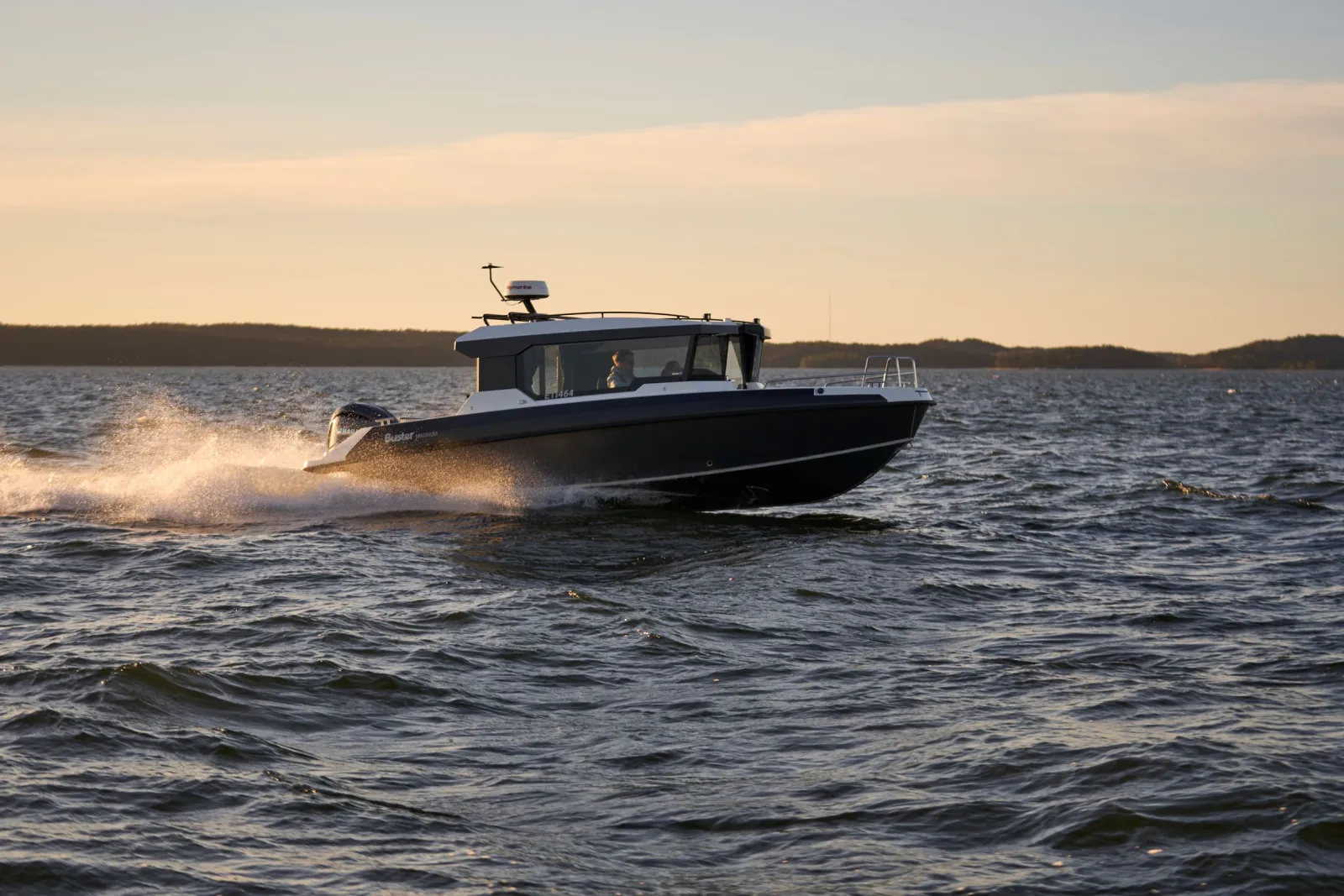 Buster Magnum Cabin, boot varend bij zonsondergang