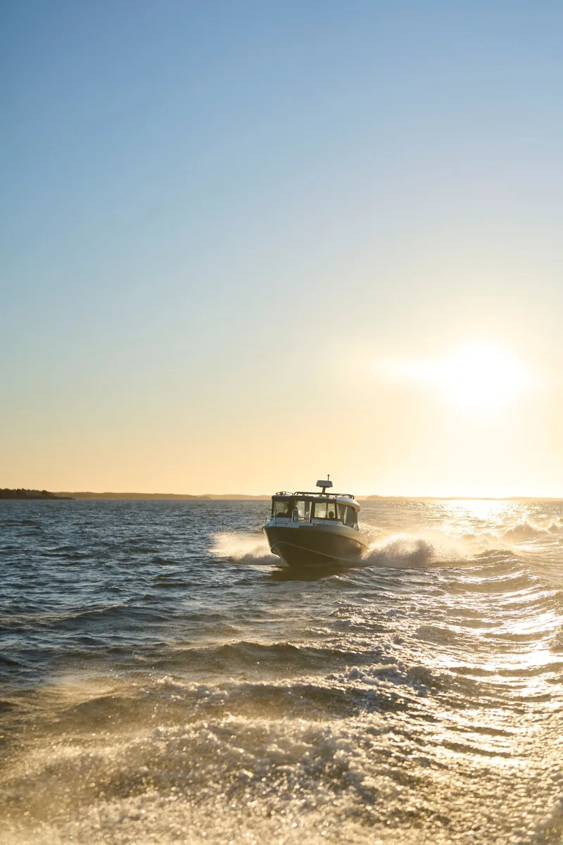 Buster Magnum Cabin, boot varend bij zonsondergang
