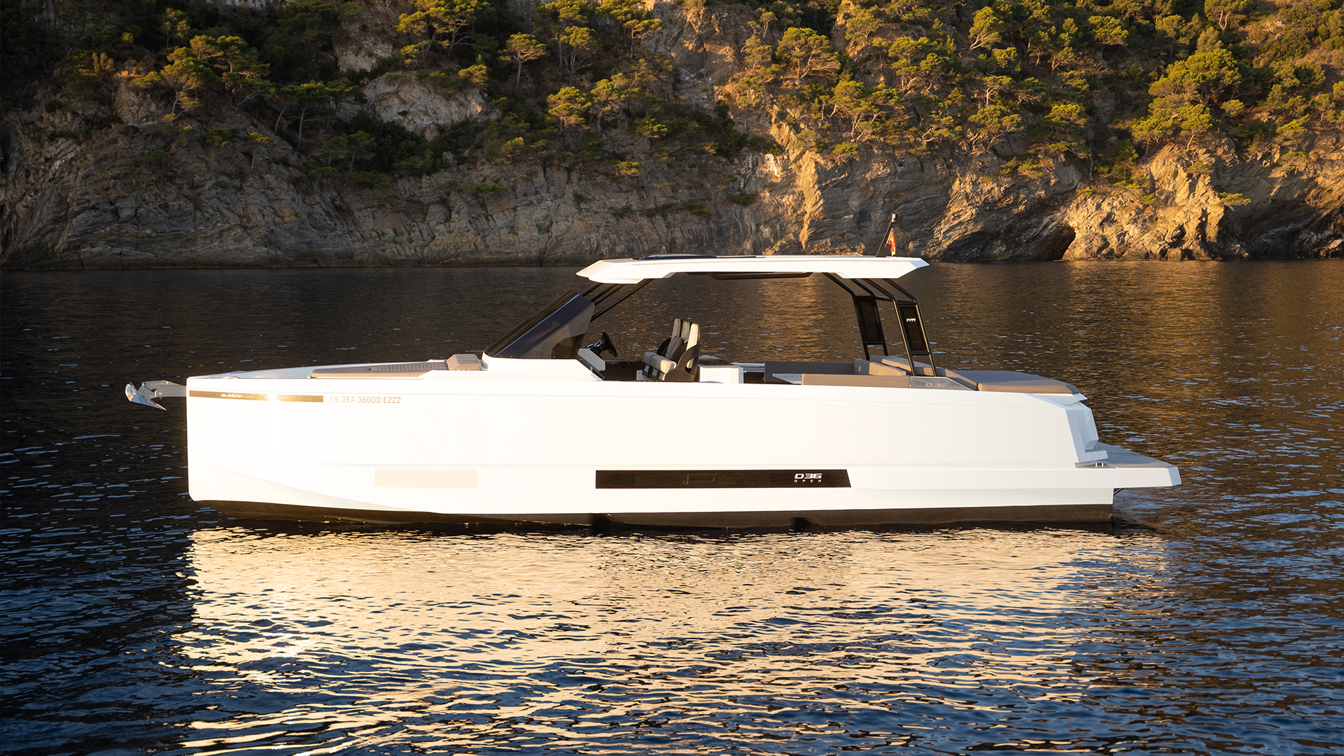 De Antonio D36 Open, witte boot afgemeerd bij rotsen