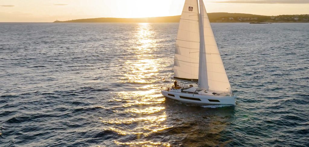 Dufour 44, zeilboot varend bij zonsondergang