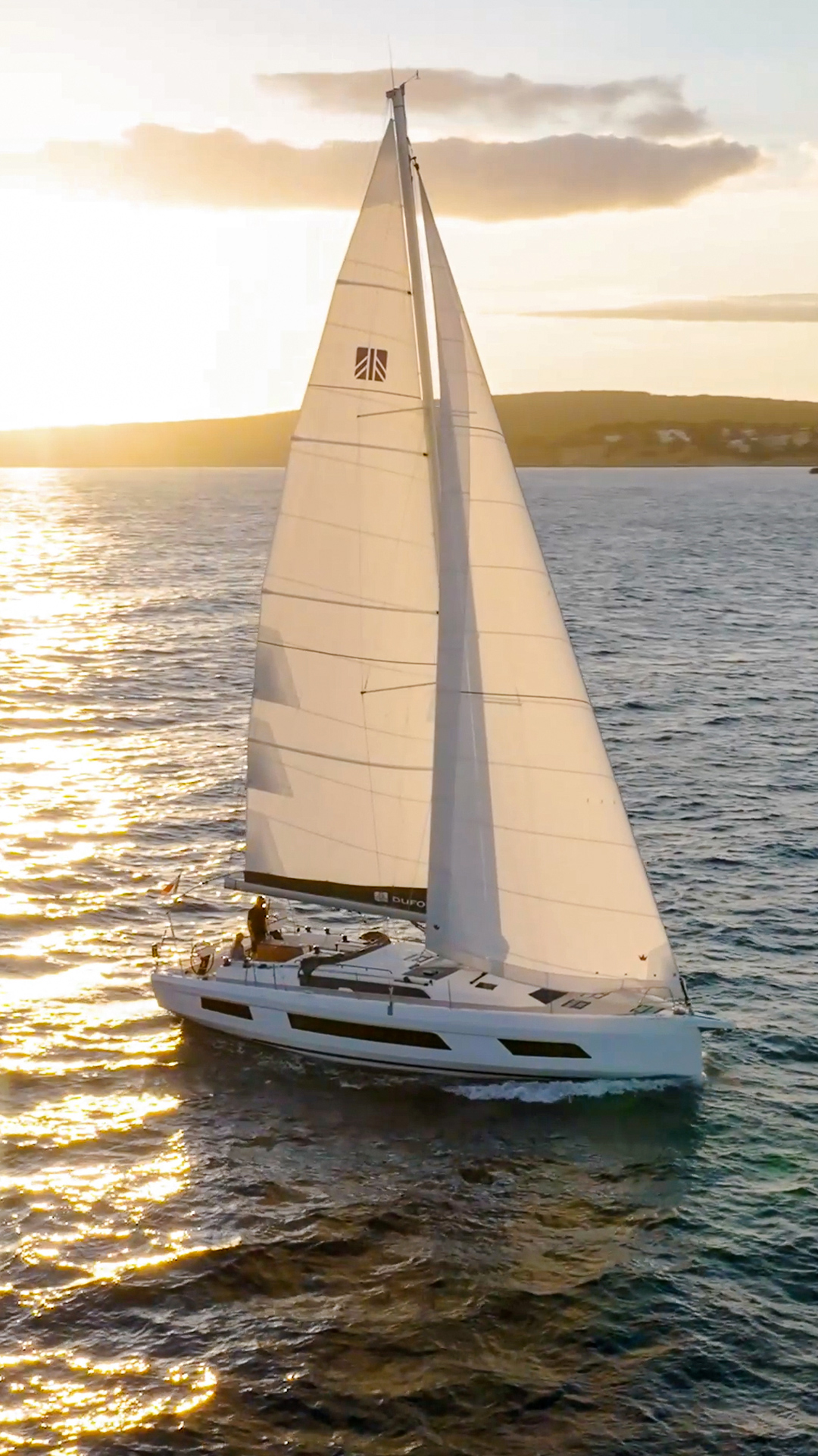 Dufour 44, zeilboot varend bij zonsondergang