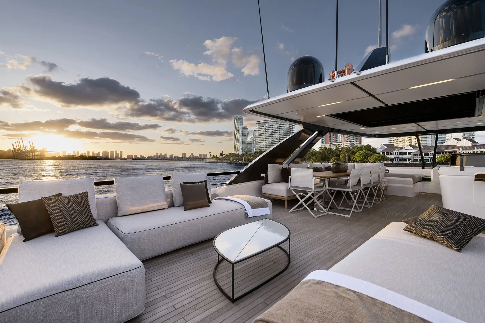 Ferretti 860, achterdek met loungebanken en zonsondergang