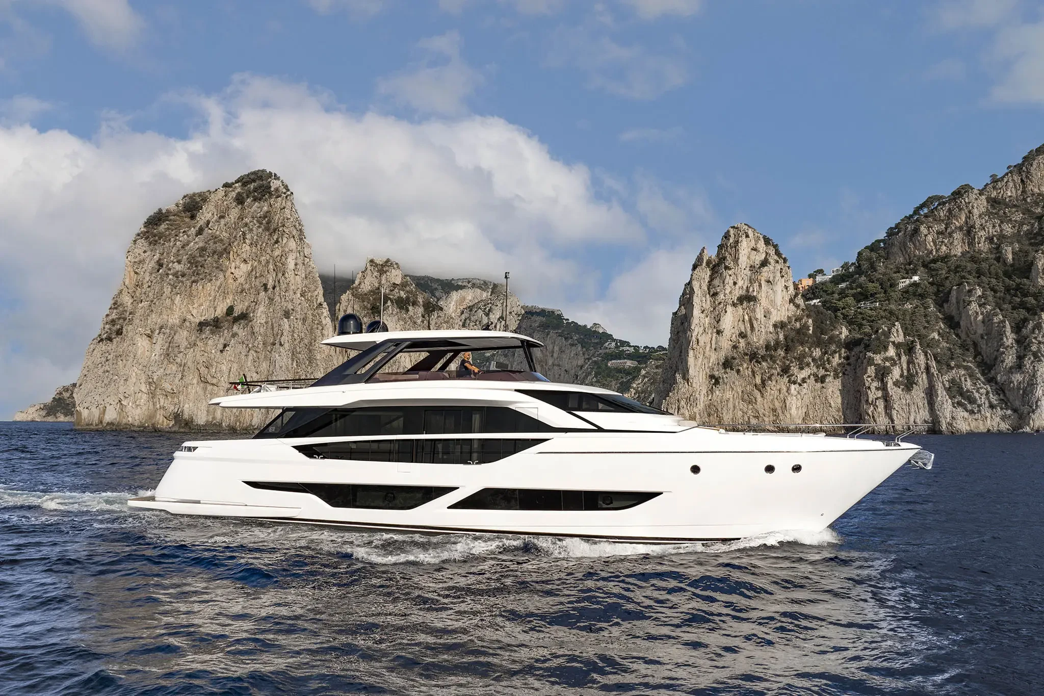 Ferretti 860, jacht varend bij rotskust