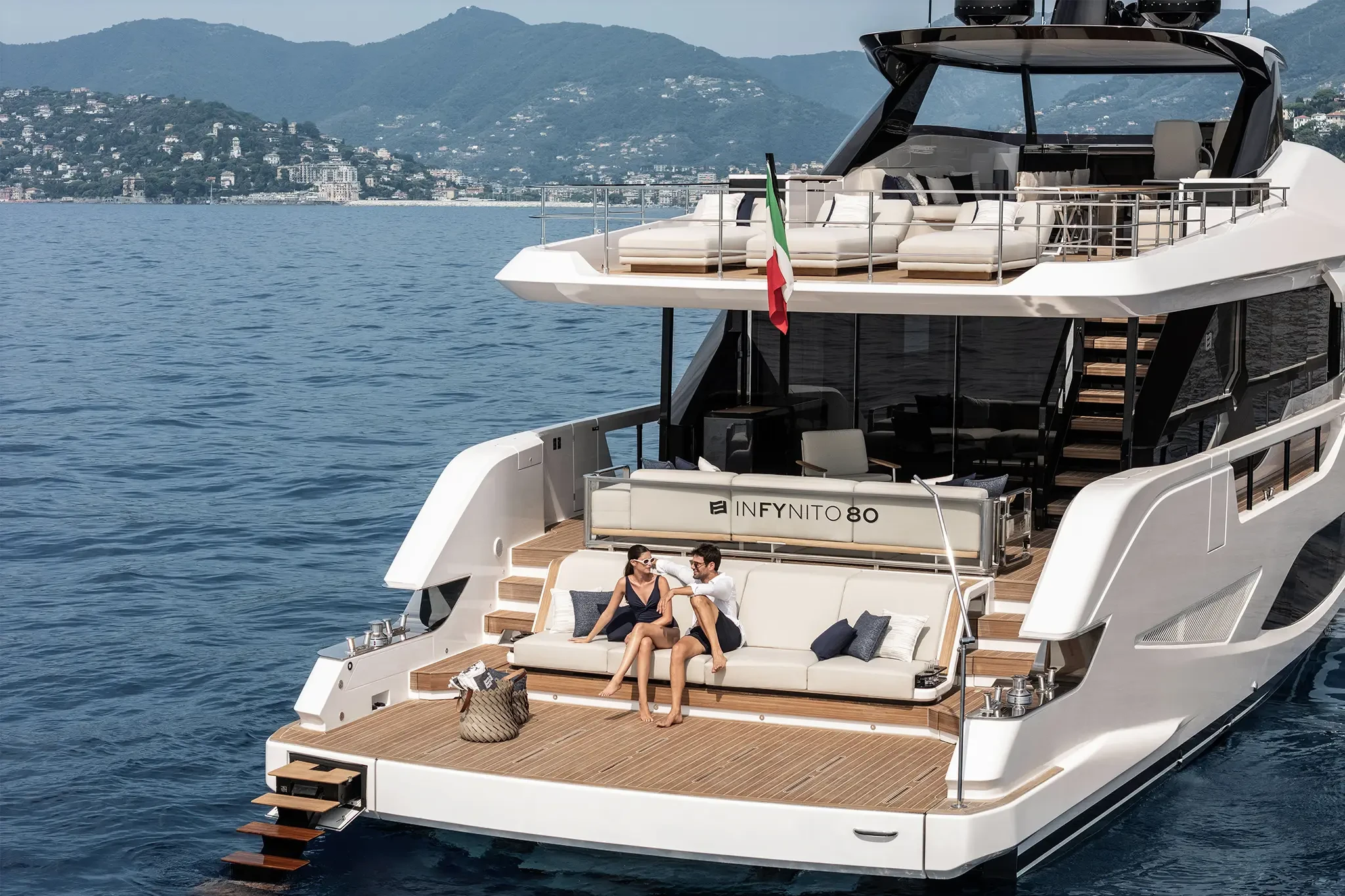 Ferretti Infynito 80, achterdek met stel op zitbank
