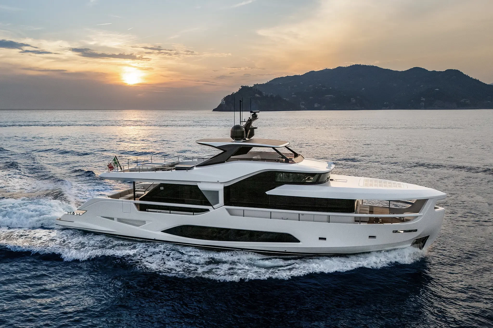 Ferretti Infynito 80, jacht varend bij zonsondergang