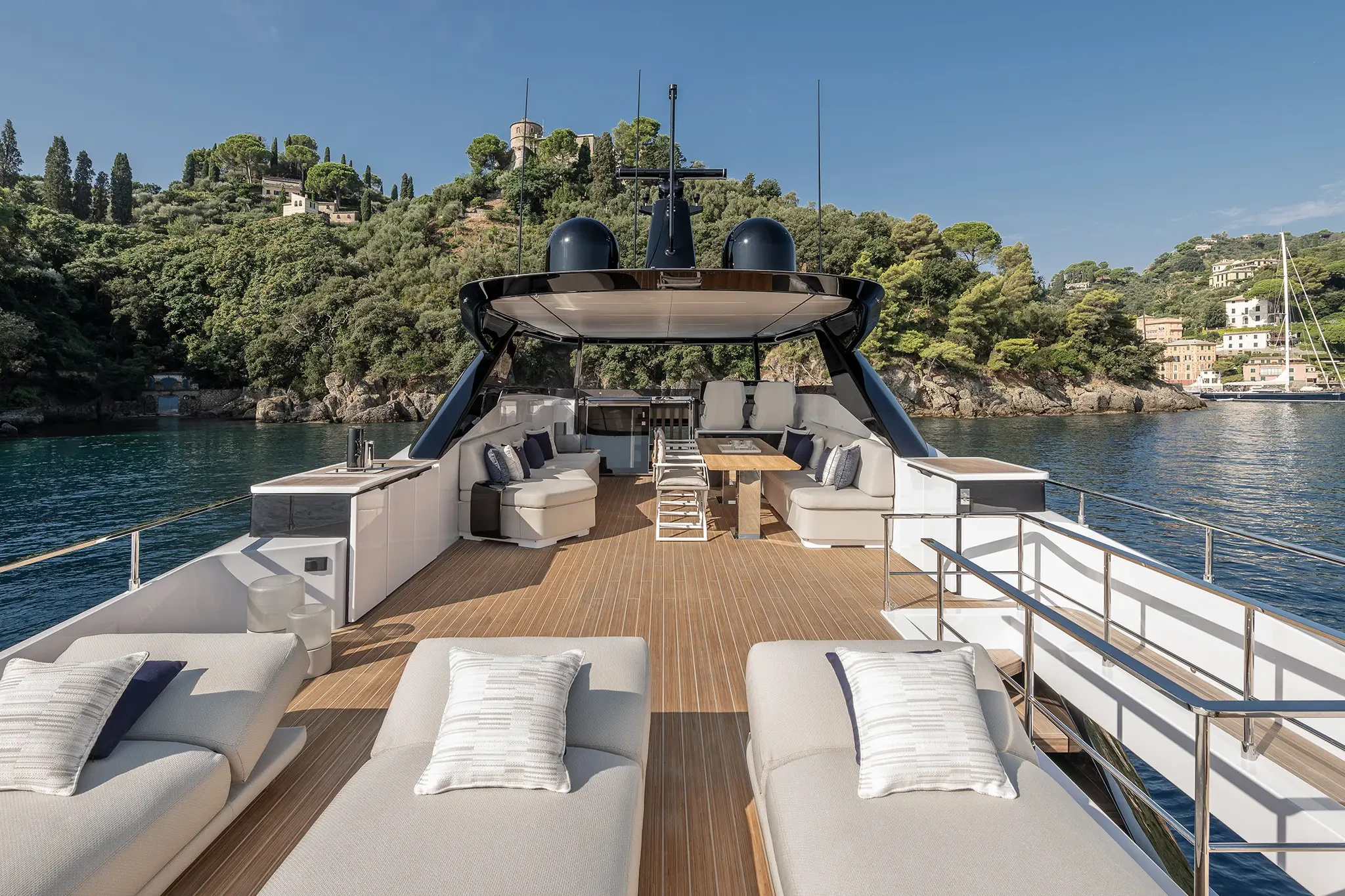 Ferretti Infynito 80, voordek met loungebanken en zicht op kust