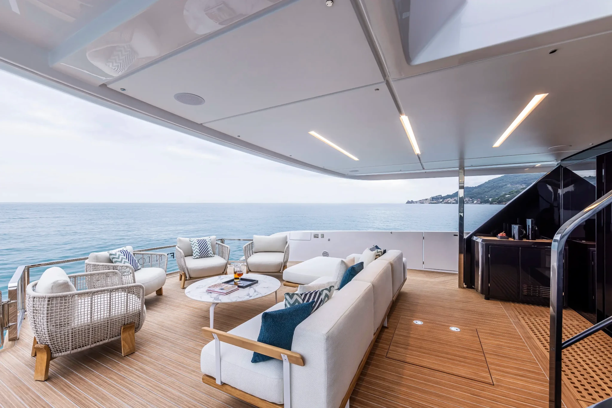 Ferretti Infynito 90, achterdek met loungebanken en zee