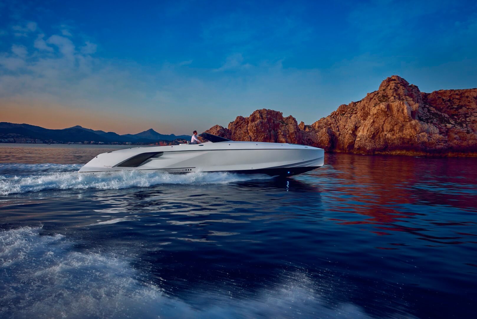 Frauscher 1414 Demon, witte speedboot vaart bij rotsen