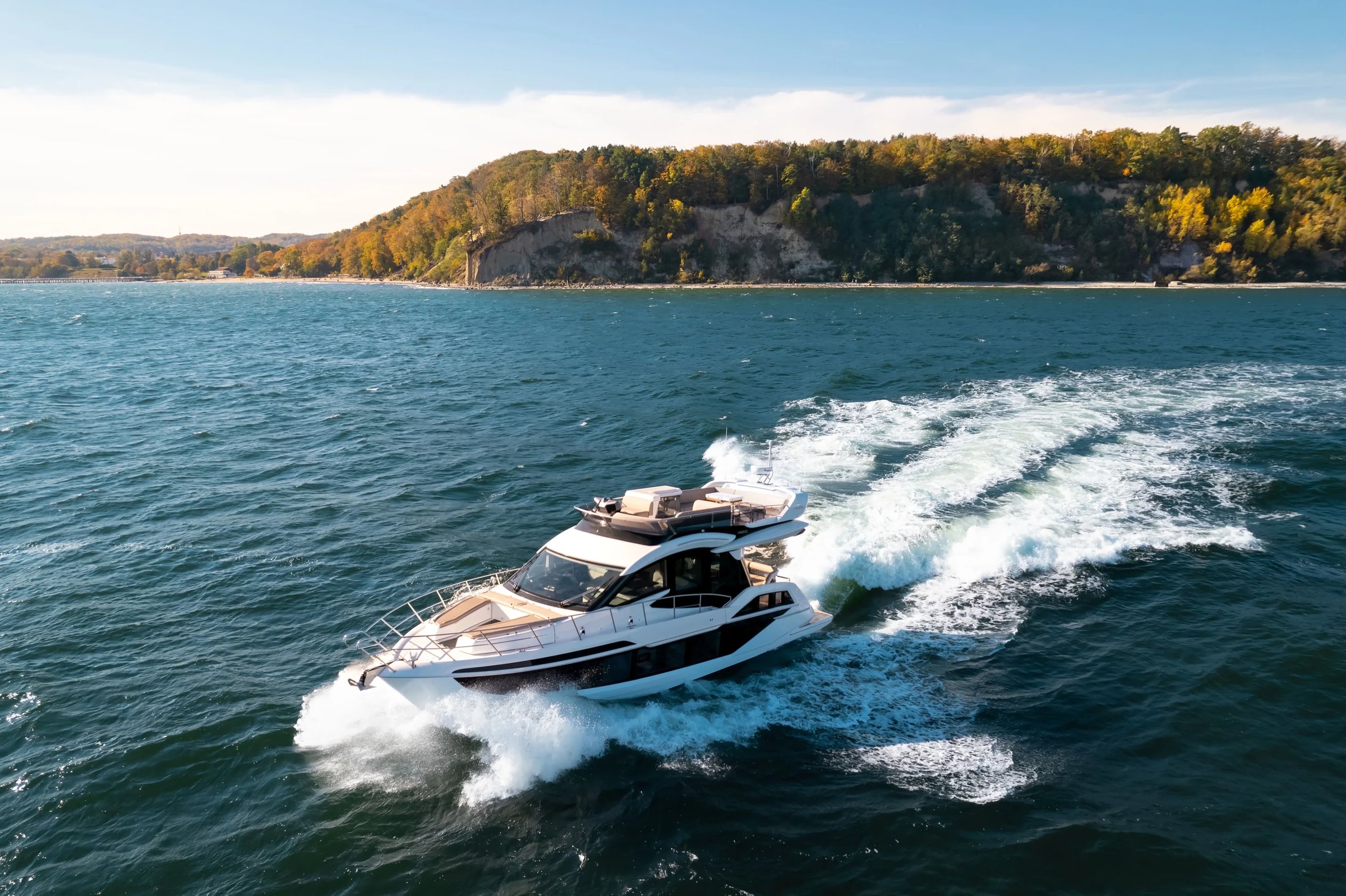 Galeon 480 FLY, jacht varend op zee met kustlijn