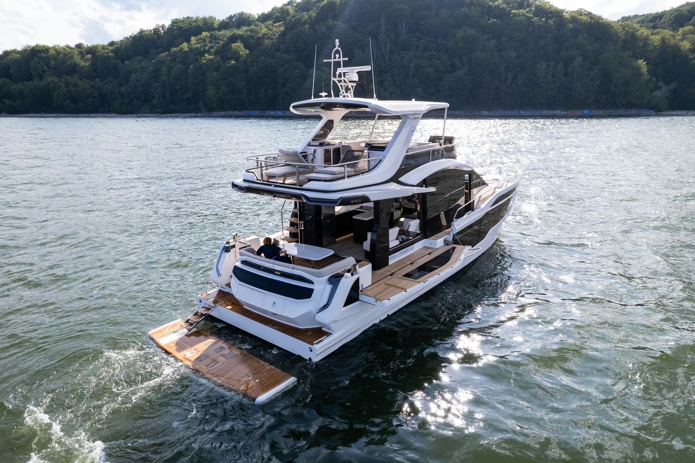 Galeon 560 FLY, boot varend op water met zwemplatform