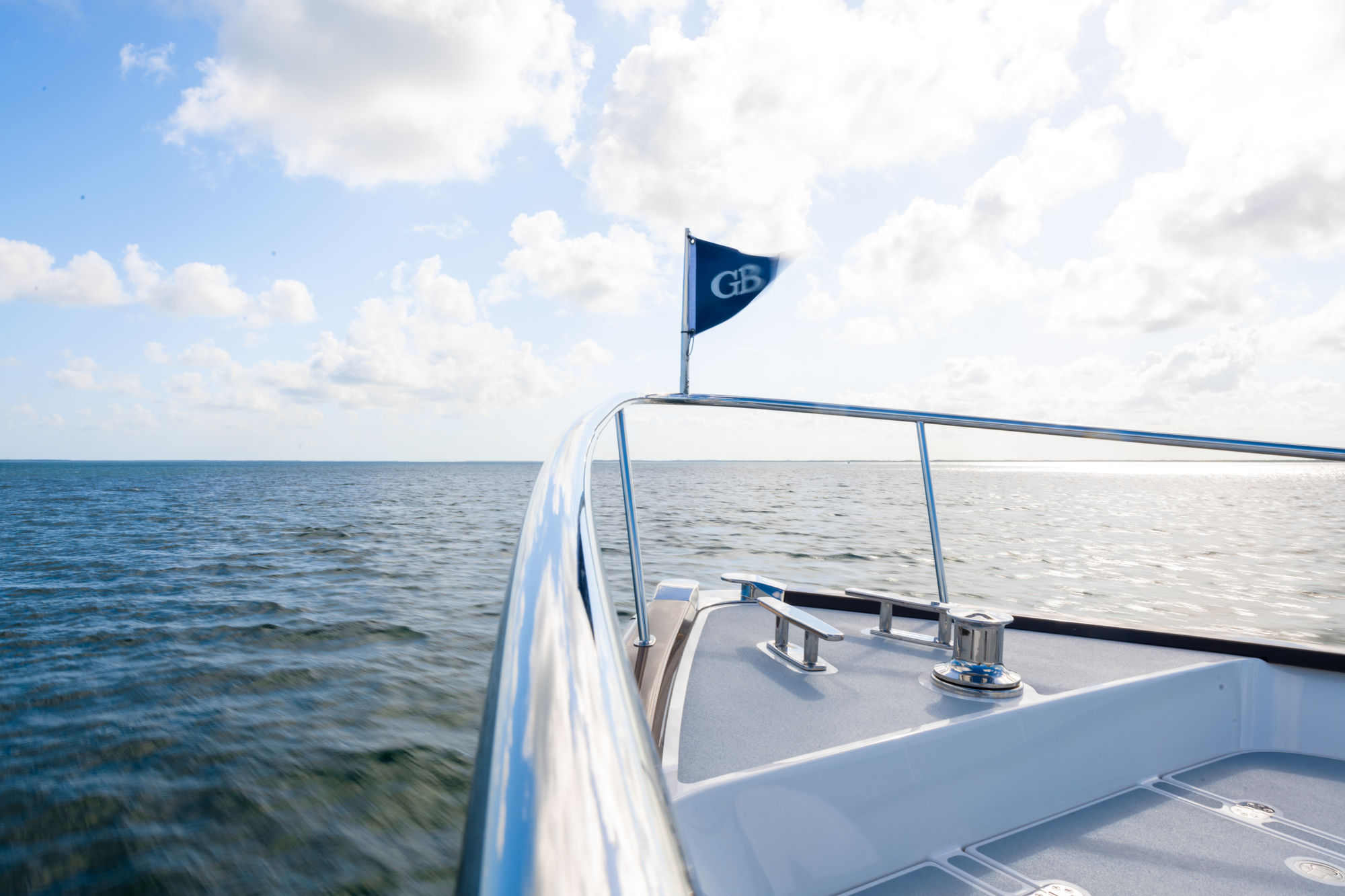 Grand Banks 73, boeg boot met vlag op zee
