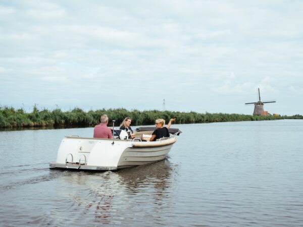 Lifestyle 570 e-Tender, boot varend op water bij molen