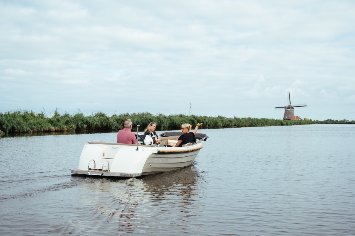 Lifestyle 570 e-Tender, boot varend op water bij molen