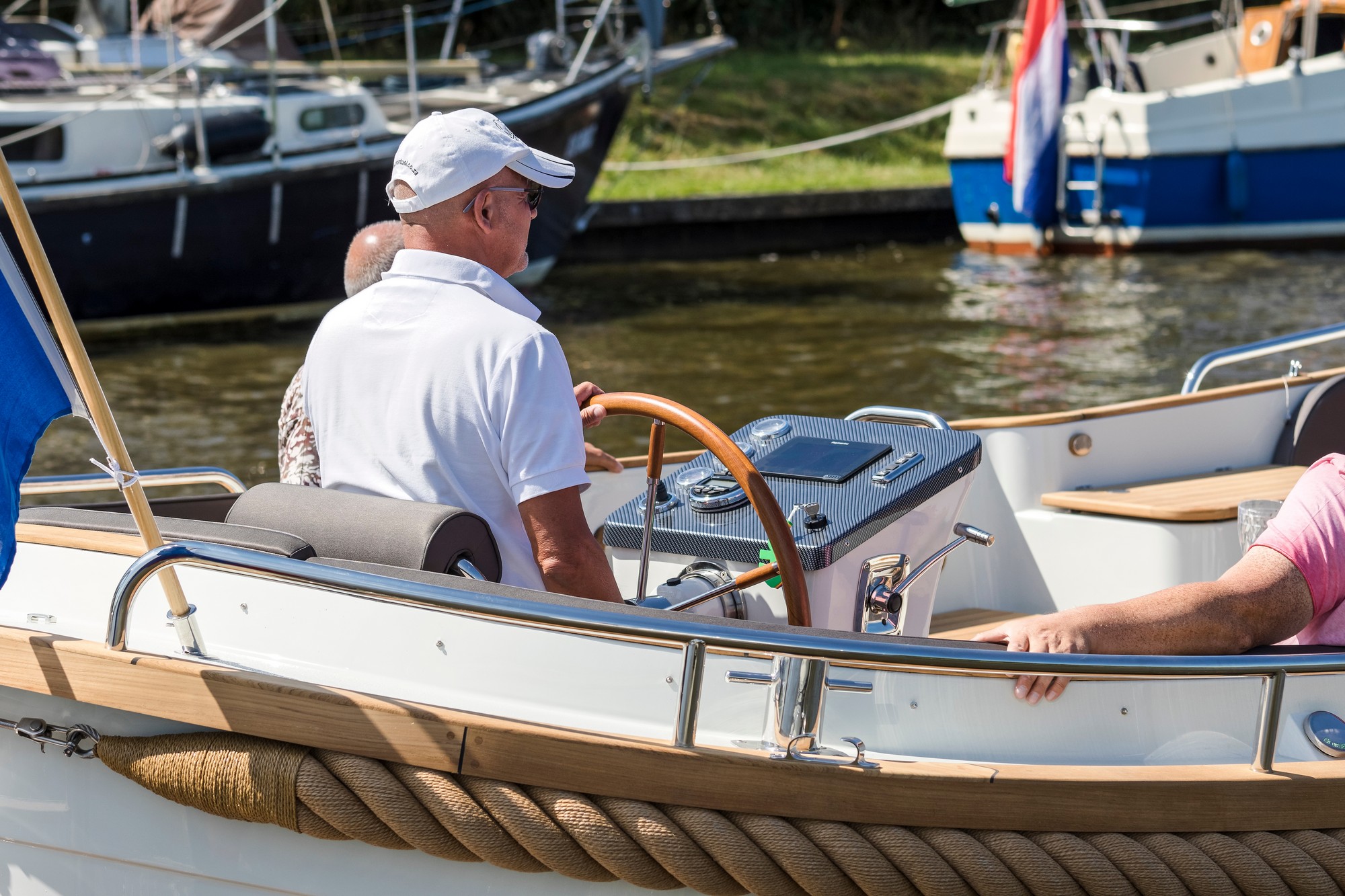 Maril 880, man aan stuurwiel boot