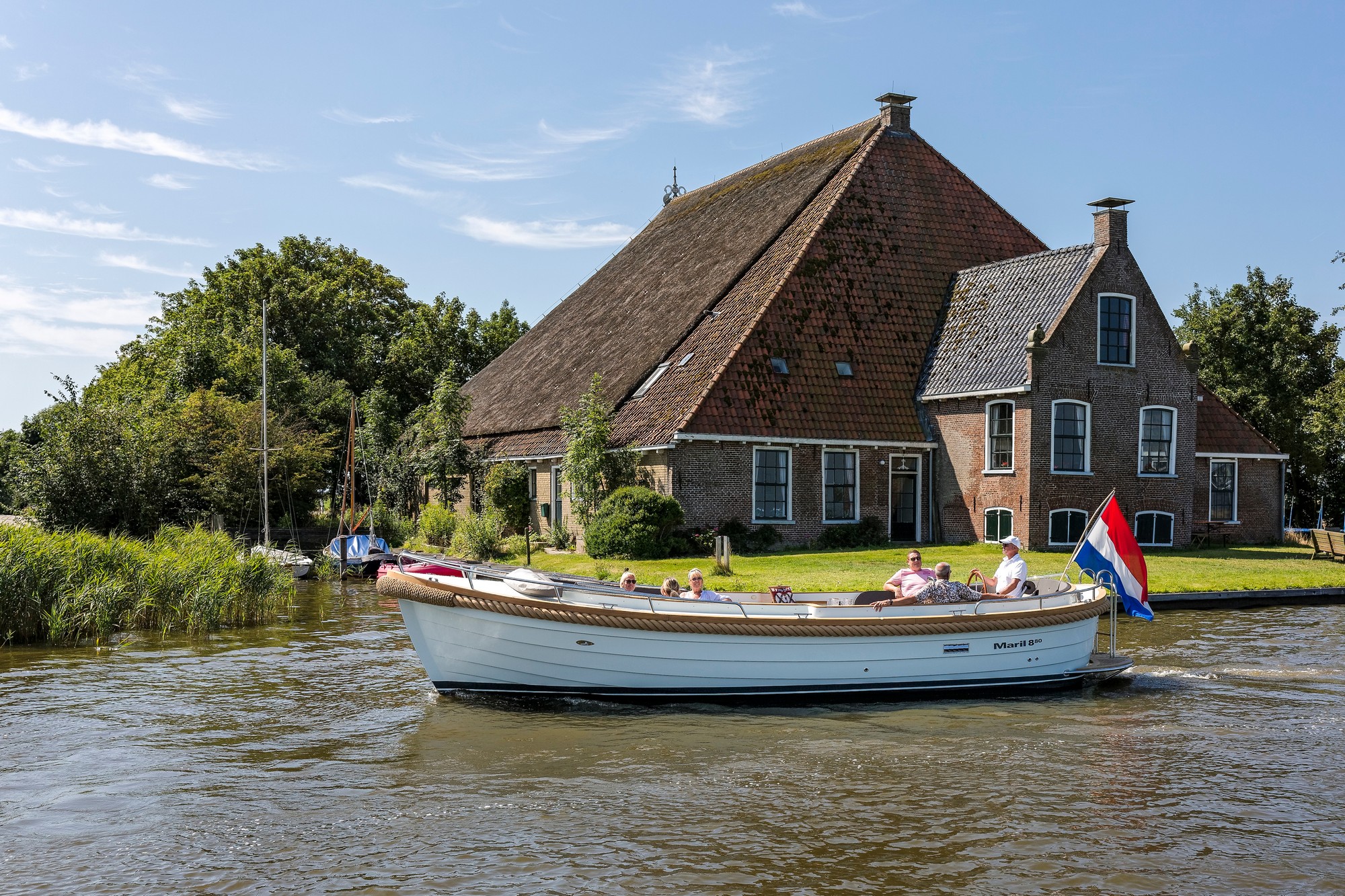 Maril 880, sloep vaart langs boerderij
