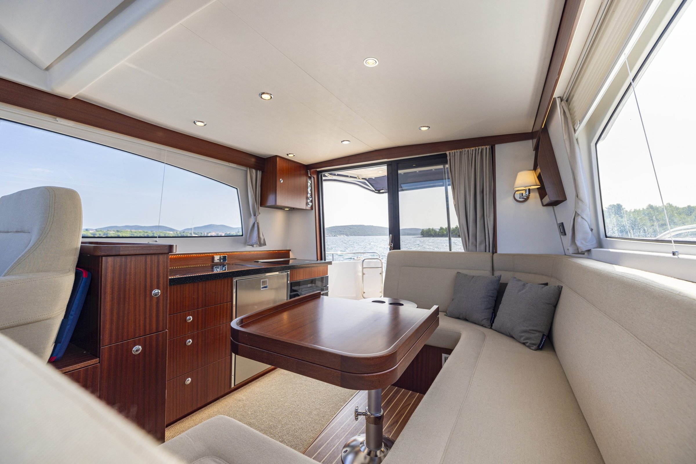 Nimbus 405 Flybridge, salon met eettafel en zitbank