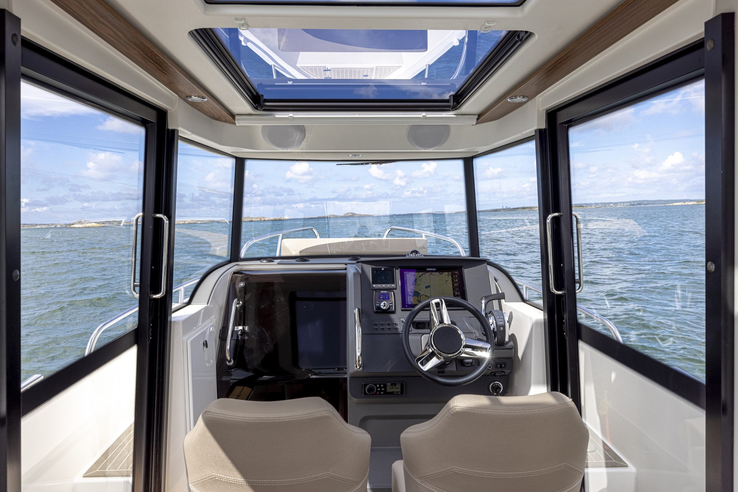 Nimbus C8, stuurstand met navigatie schermen en zicht op zee