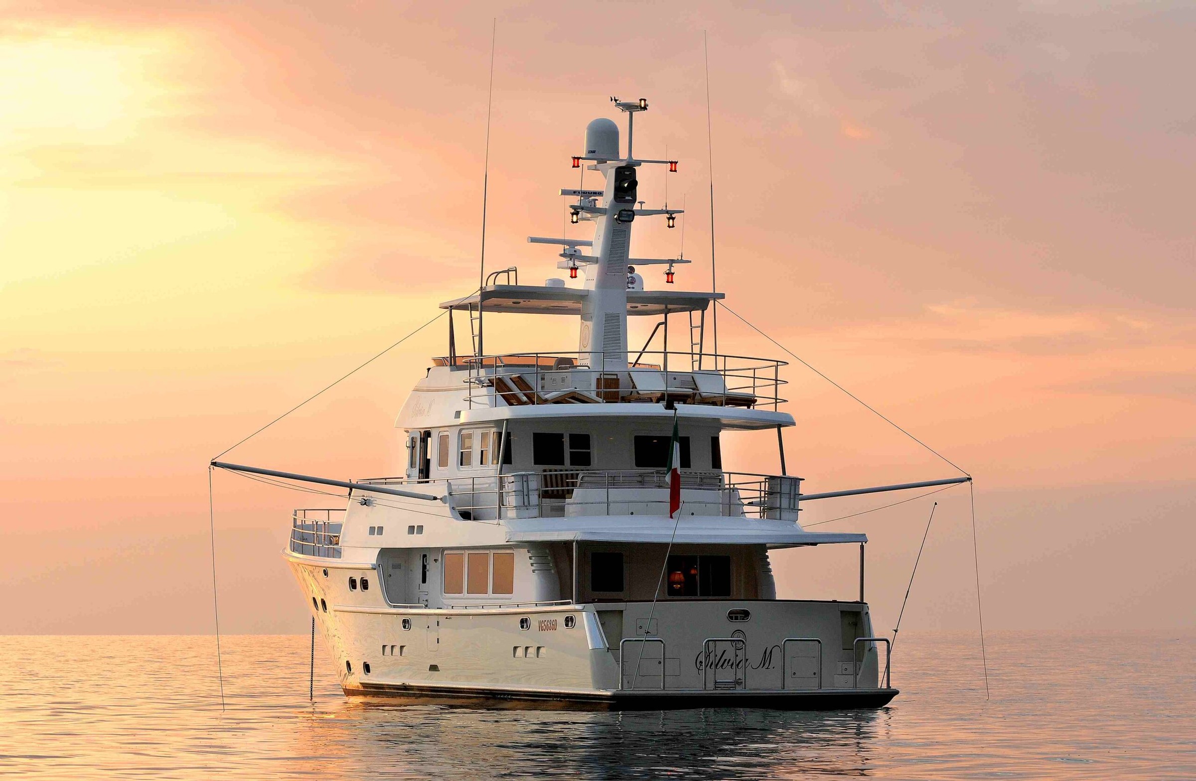 Nordhavn 76, jacht op zee bij zonsondergang