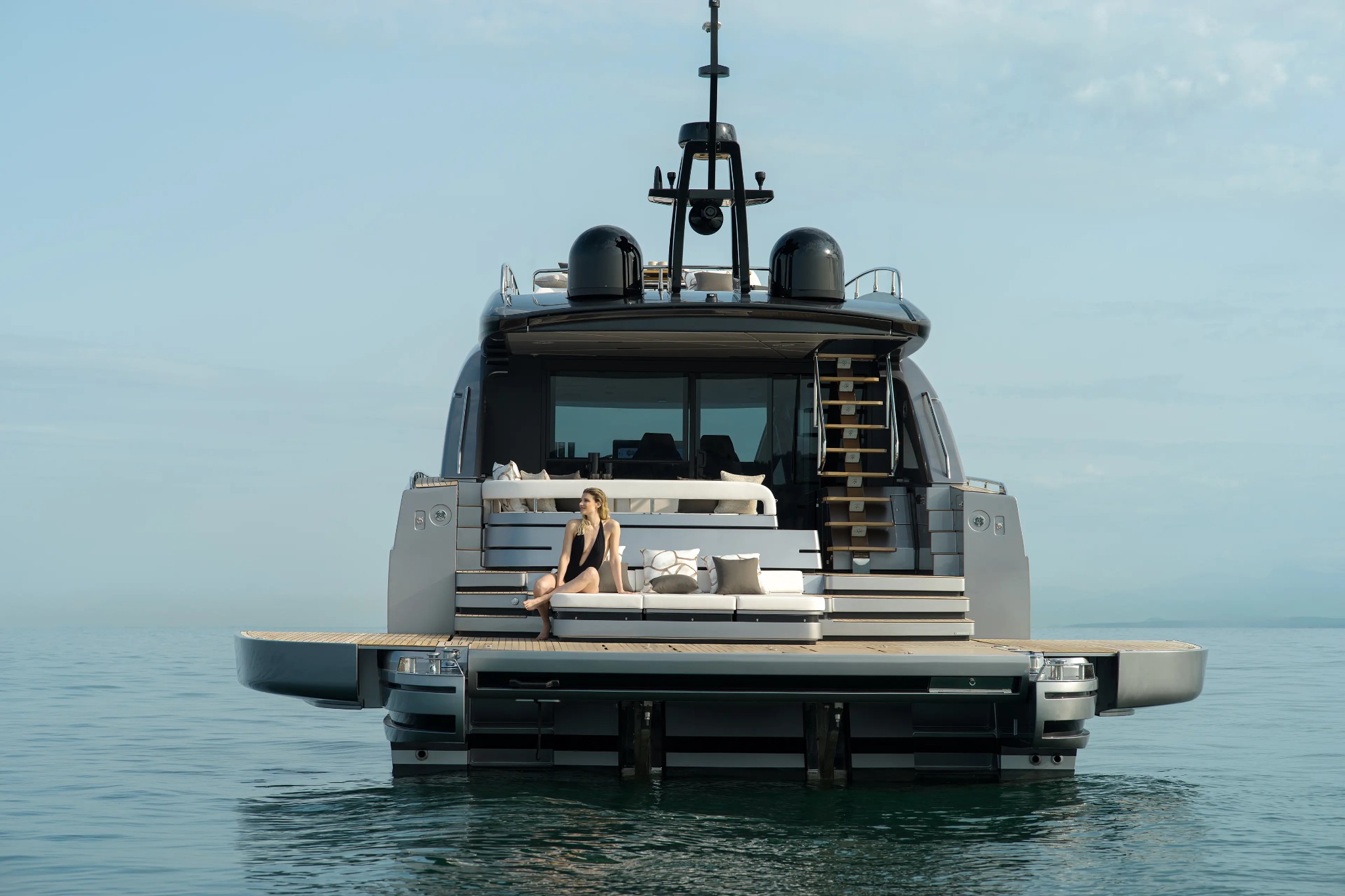 Pershing GTX70 New, achtersteven jacht met vrouw op zwemplatform