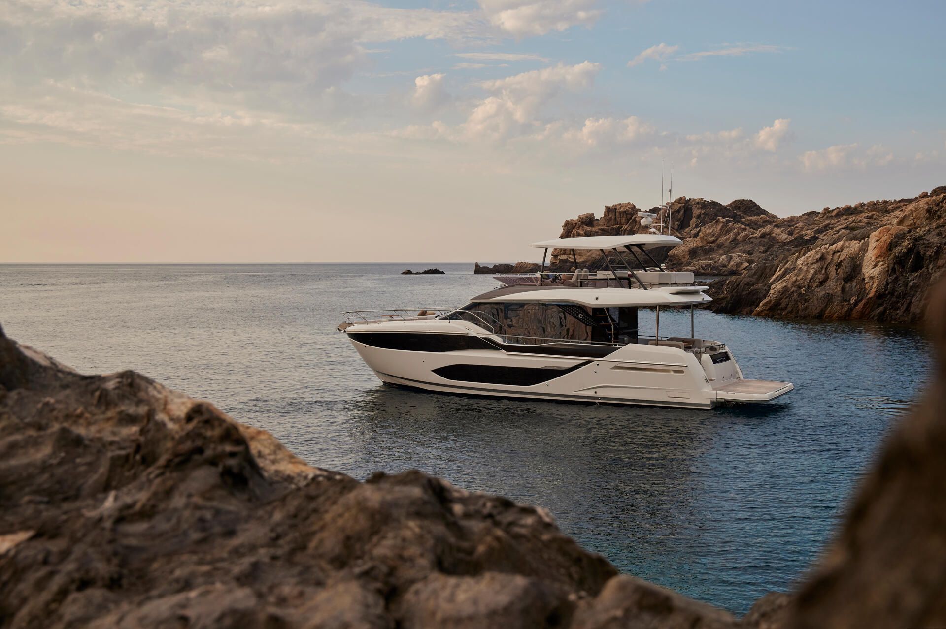 Prestige F5.7, jacht afgemeerd bij rotsachtige baai