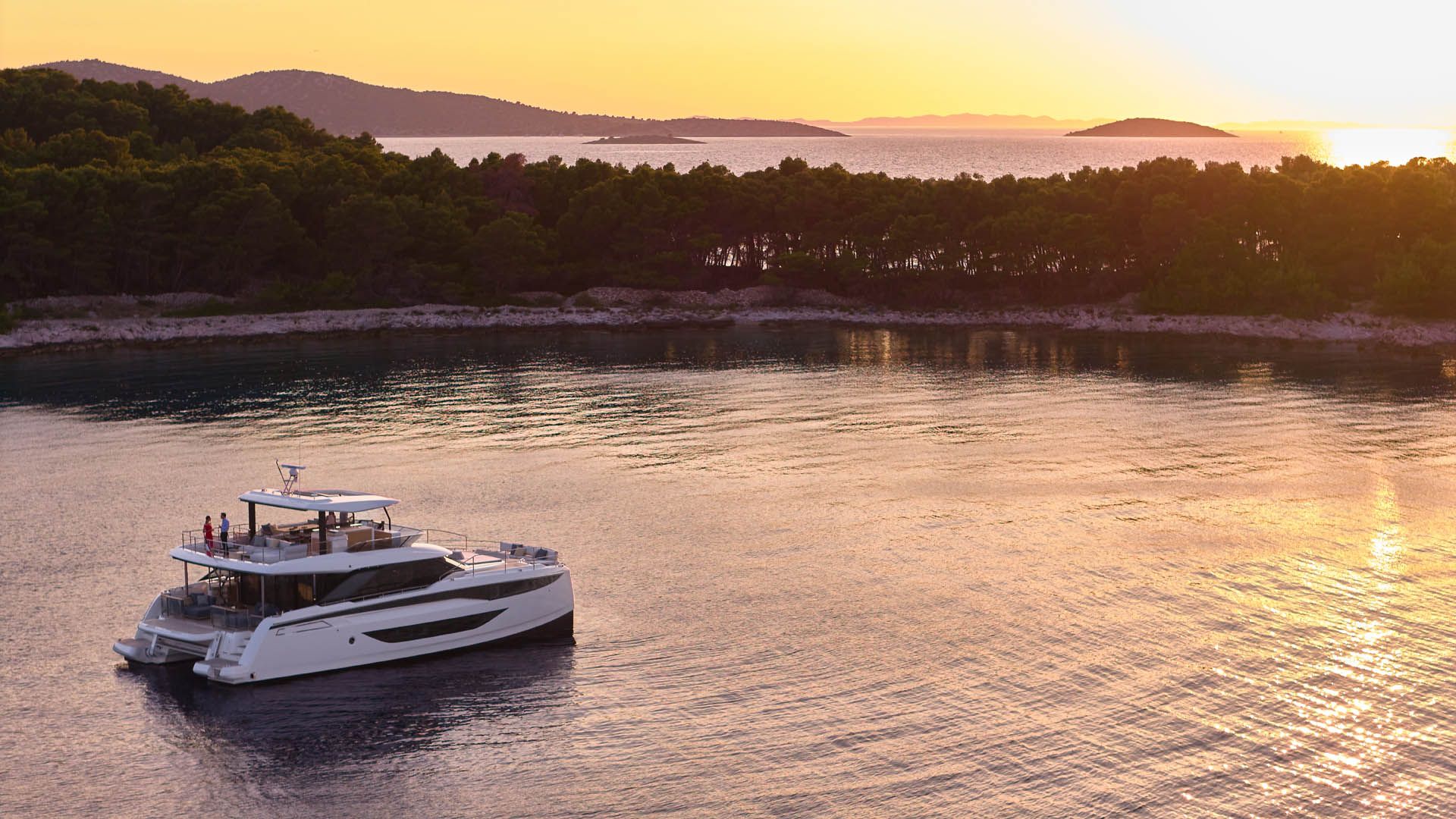 Prestige M8 EVO, catamaran voor anker bij zonsondergang